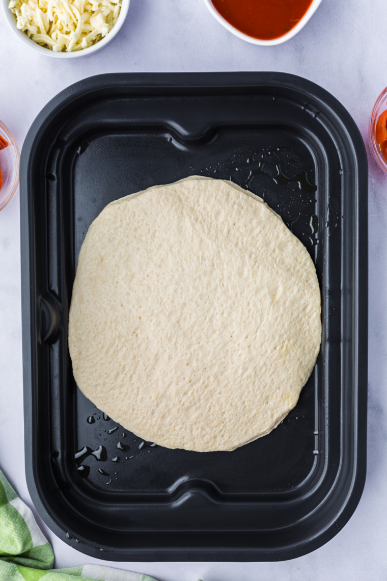 Dough balls warming at room temperature, covered, before stretching and topping.