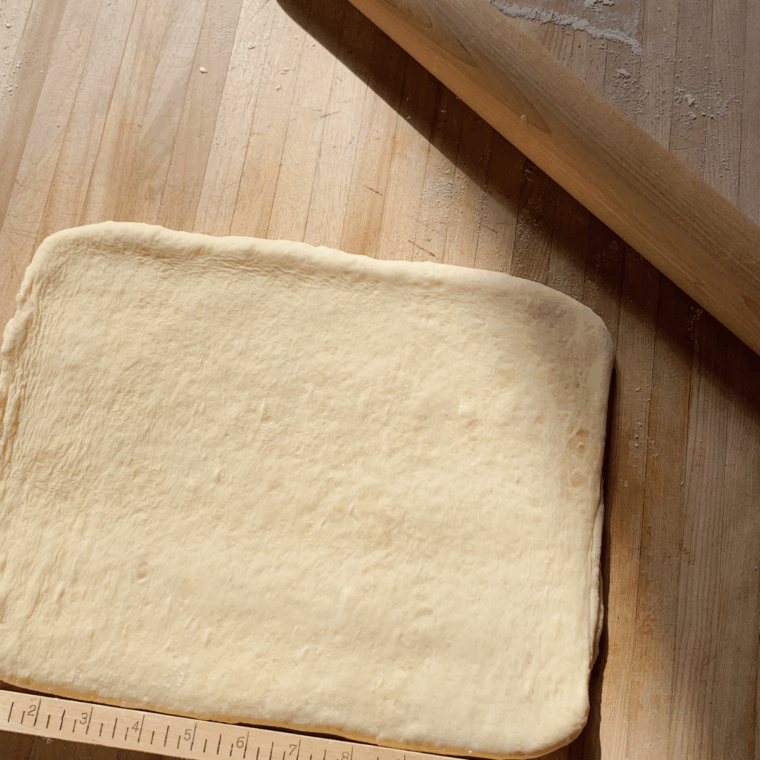 Puff pastry sheet brushed with melted butter on counter