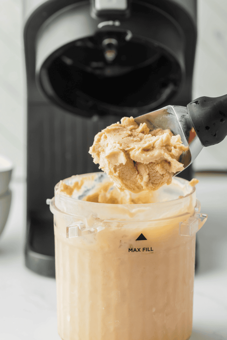 Scoop of White Chocolate Mocha Frappuccino® ice cream in a bowl topped with whipped cream and chocolate drizzle.