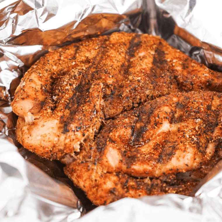 Homemade Copycat Tony Chachere’s Creole Seasoning in a small jar with colorful spices.