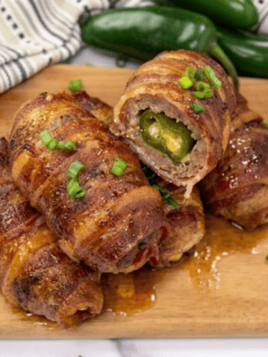 Crispy bacon-wrapped Air Fryer Armadillo Eggs on a plate with melted cheese oozing out.