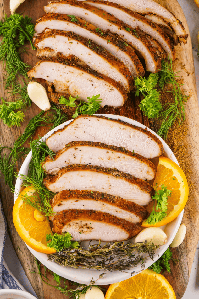 Juicy, perfectly smoked Cajun turkey breast sliced and arranged on a serving platter.