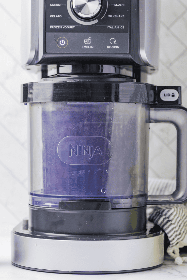 Placing frozen pint in Ninja Creami with Creamerizer™ Paddle installed.