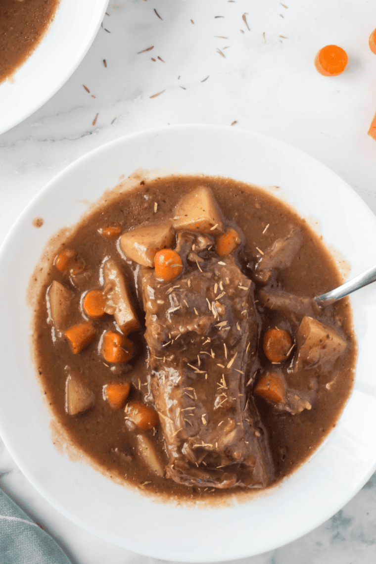 Slow cooker beef sirloin tip roast sliced and served with rich, savory gravy and fresh herbs.