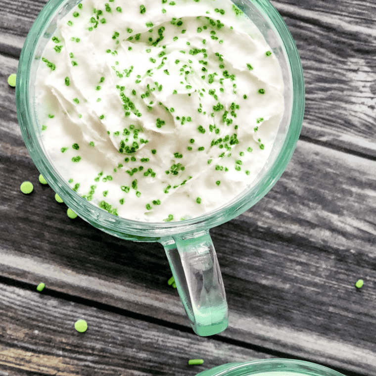 Bright green Ninja Slushie Shamrock Shake in a tall glass with whipped cream and festive sprinkles.