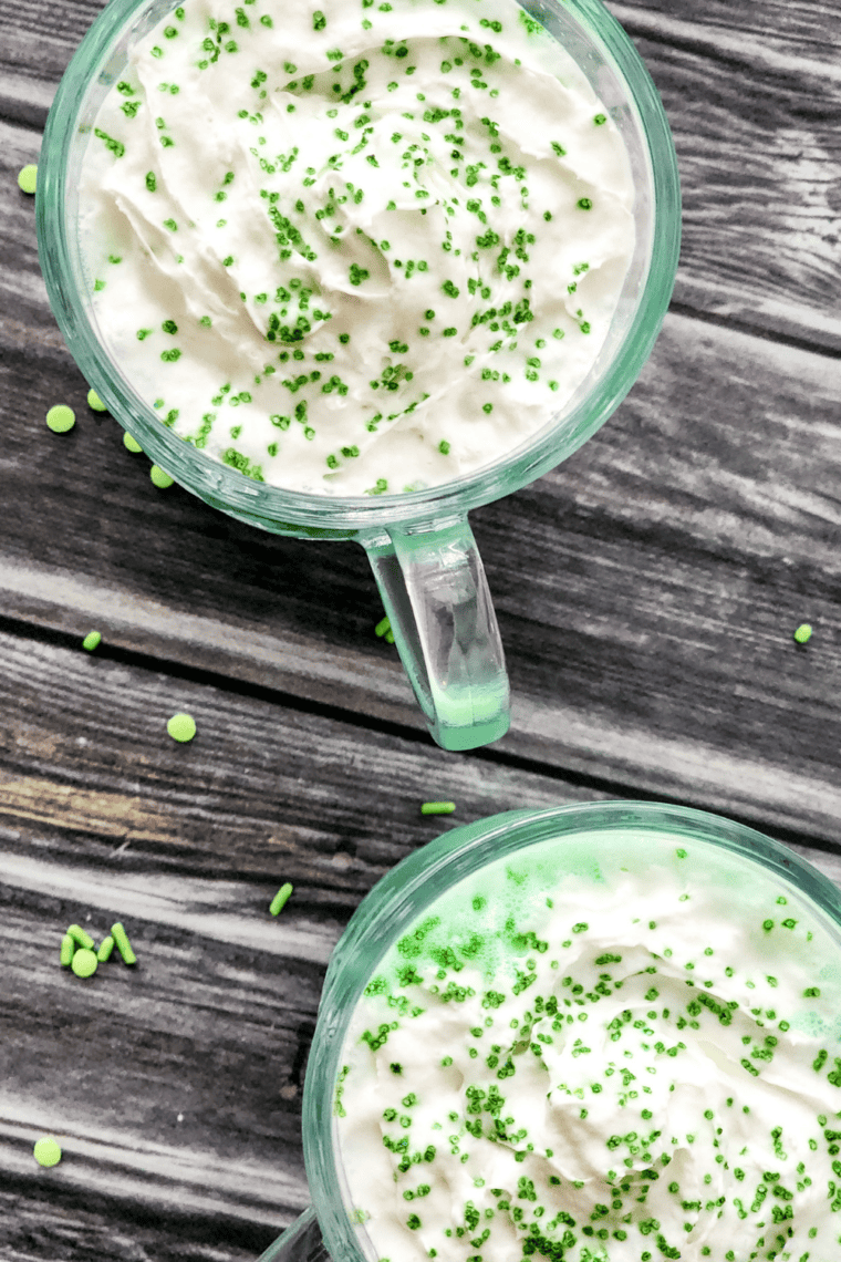 Minty green Ninja Slushie Shamrock Shake in a glass topped with whipped cream and sprinkles.