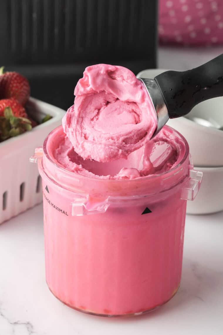 Scooping homemade Ninja Creami bubble gum ice cream into a bowl ready to serve.