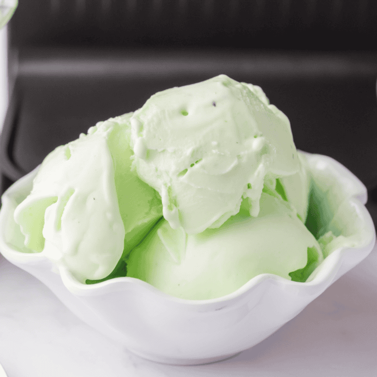 Homemade green mint ice cream made in Ninja Creami served in a cone for St. Patrick’s Day.
