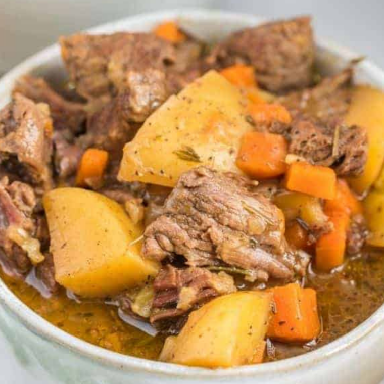 Hearty Dinty Moore style beef stew with tender chunks of beef, potatoes, carrots, and thick brown gravy in a rustic bowl