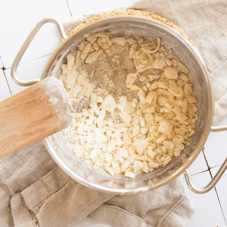 Butter melting in skillet with shallots cooking until soft and golden, then garlic added until fragrant and aromatic.