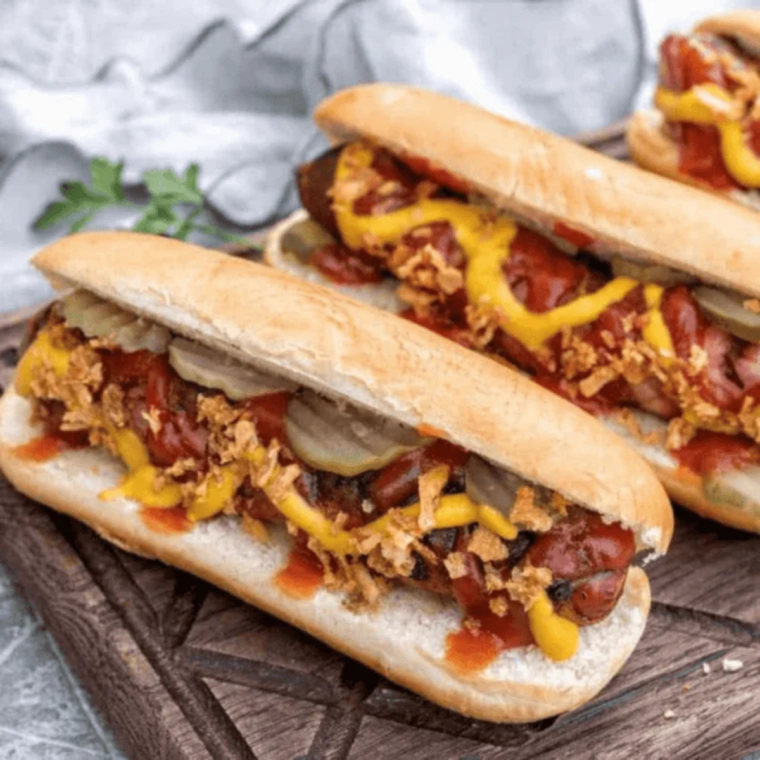 Hot dogs steaming in an Instant Pot with water at the bottom, cooked quickly and ready to serve in buns.
