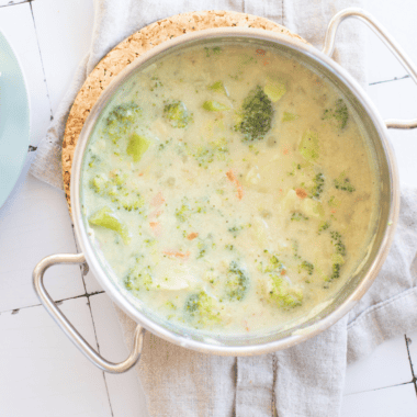 Bowl of creamy McAlister’s Broccoli and Cheddar Soup topped with melted cheddar and tender broccoli florets in a thick, cheesy base.