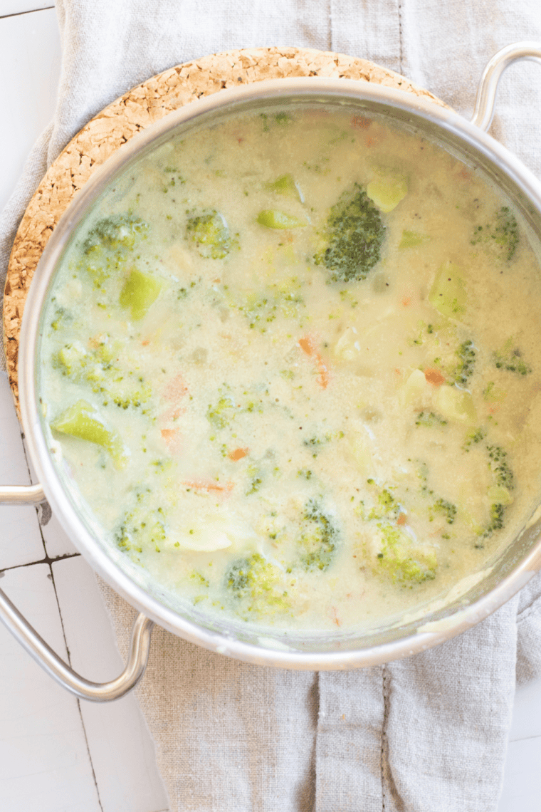 Creamy McAlister’s Broccoli and Cheddar Soup in a bowl topped with melted cheddar cheese and tender broccoli florets in a thick, golden cheese base.