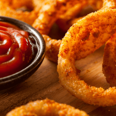 Homemade Red Robin spicy ketchup served in a small bowl with crispy fries for dipping, rich red sauce with a hint of spice