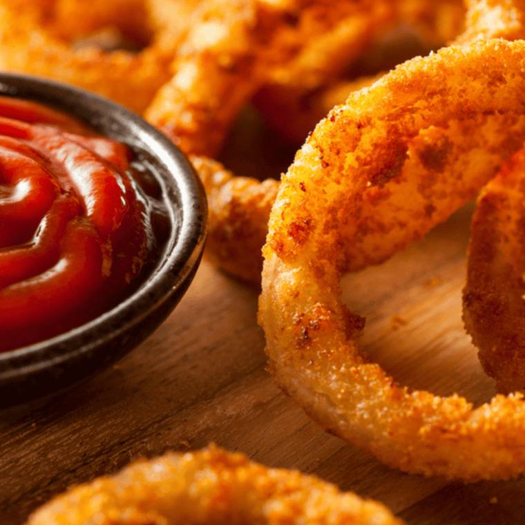Homemade Red Robin spicy ketchup served in a small bowl with crispy fries for dipping, rich red sauce with a hint of spice