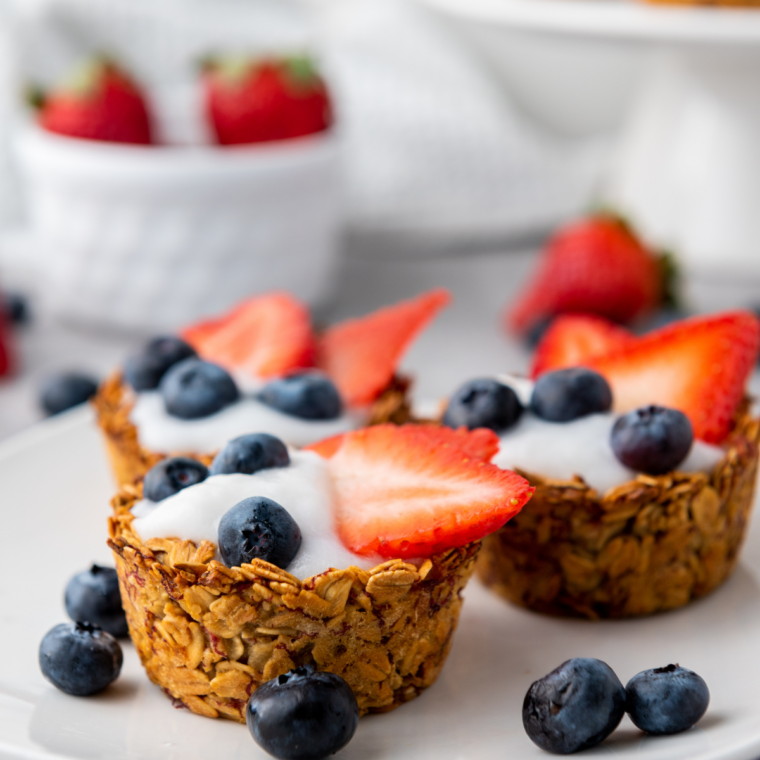 Red white and blue granola berry cups layered with fresh berries and crunchy granola in clear cups