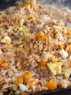 Fried rice cooking on Blackstone griddle with spatula