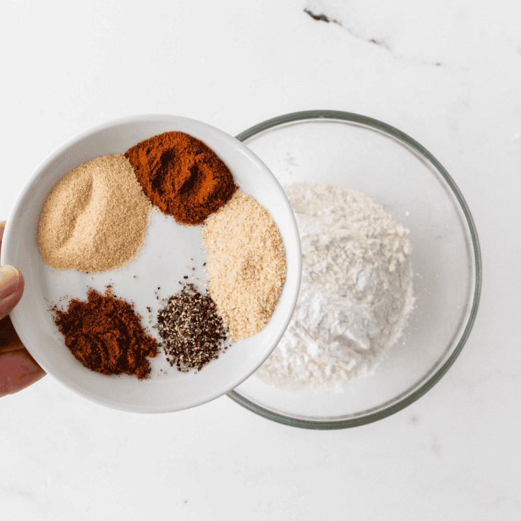 Small bowl of mixed spices being whisked together into a uniform seasoning blend for Zaxby’s fry seasoning.