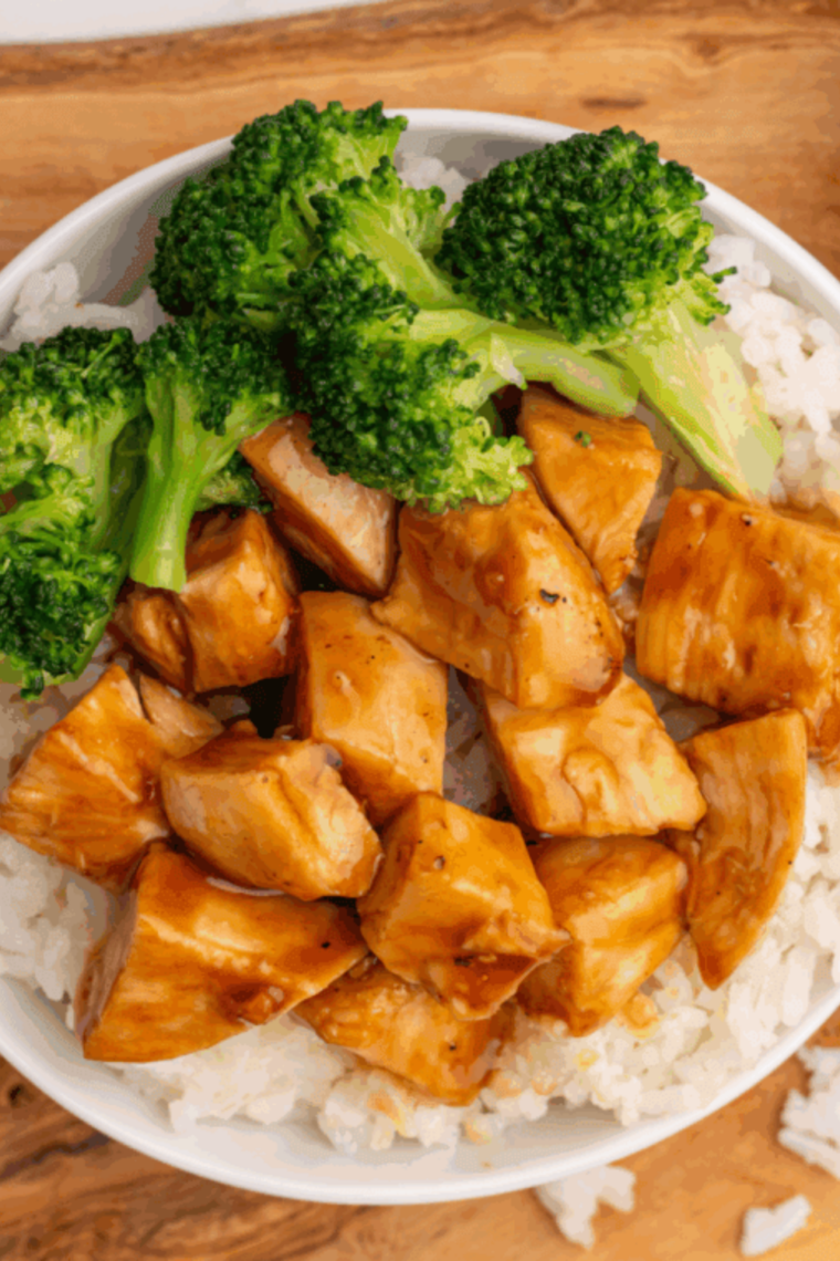 Healthy chicken bowls with grilled chicken, rice, and fresh vegetables arranged on a table.