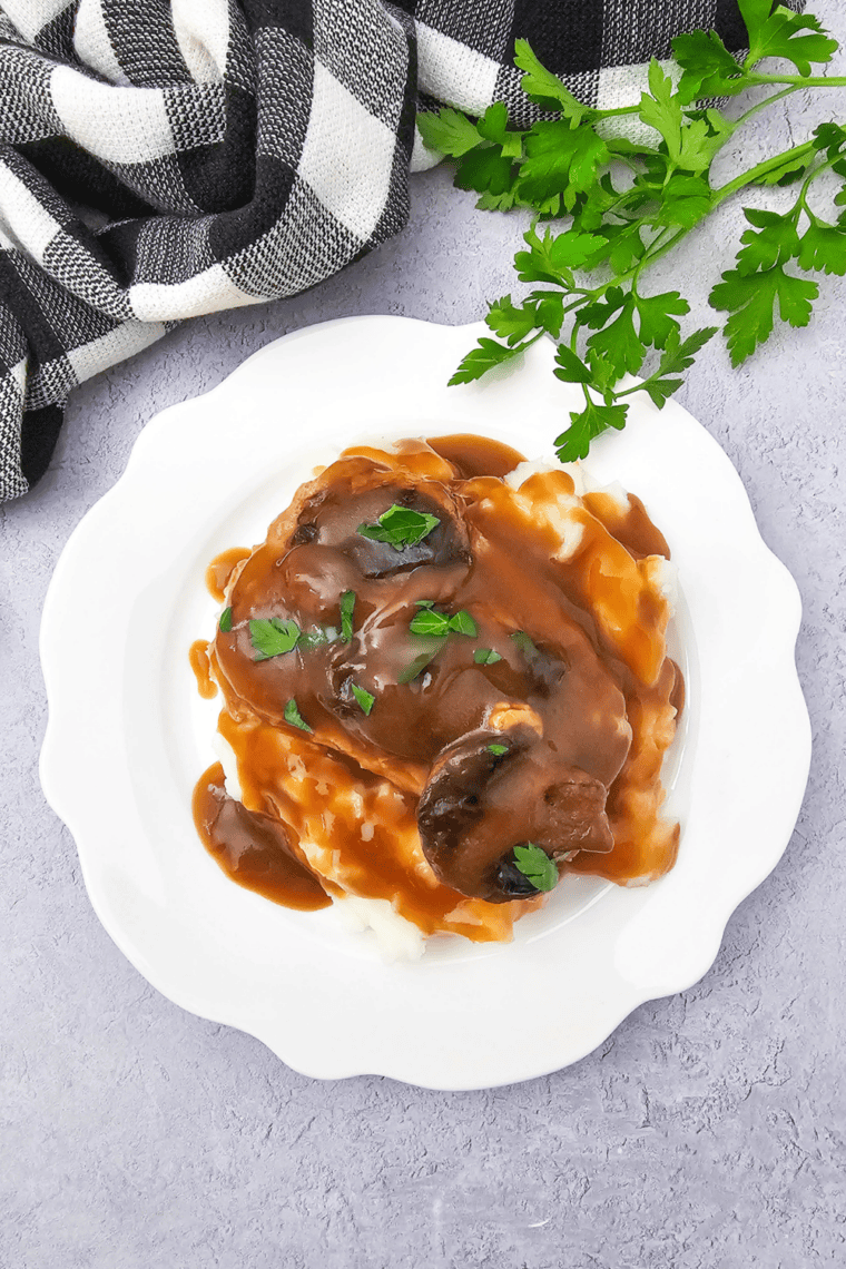 Close-up of crock pot pork chops coated in creamy mushroom onion gravy.
