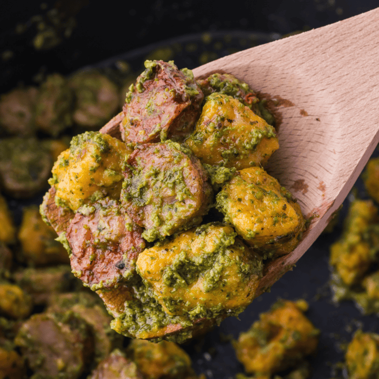 Sweet potato gnocchi cooking in air fryer basket until golden