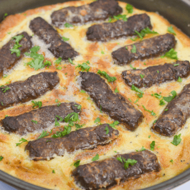 Golden, puffed-up air fryer toad in the hole with browned sausages nestled in crispy Yorkshire pudding batter