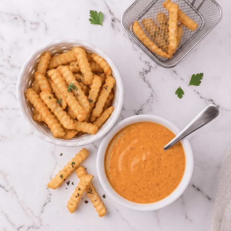 Burger King buffalo sauce served in a small container with chicken tenders and fries.