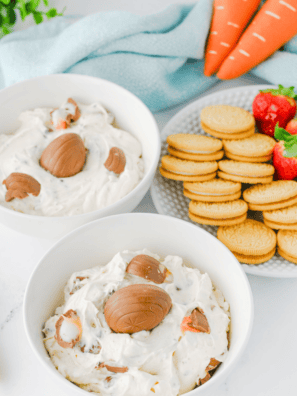 Creamy Cadbury Egg Dip topped with pastel Mini Eggs in a white serving bowl
