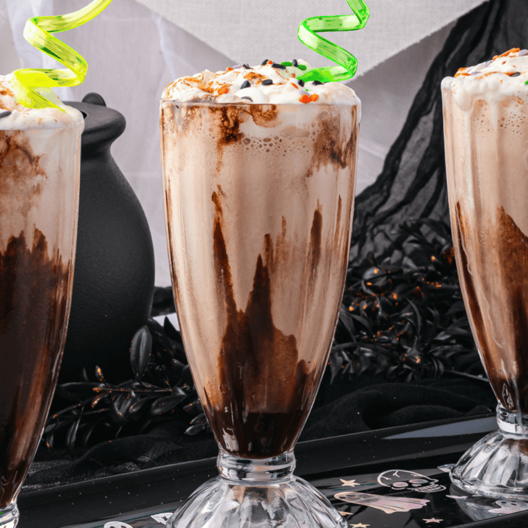 Finished Caramel Macchiato Milkshake topped with whipped cream, caramel drizzle, and espresso beans in a caramel-ribboned glass.