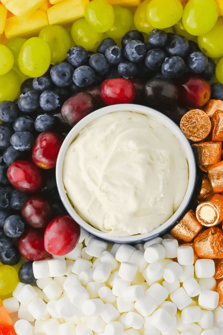 Homemade Jason's Deli fruit dip recipe served with sliced strawberries and pineapple on a wooden board
