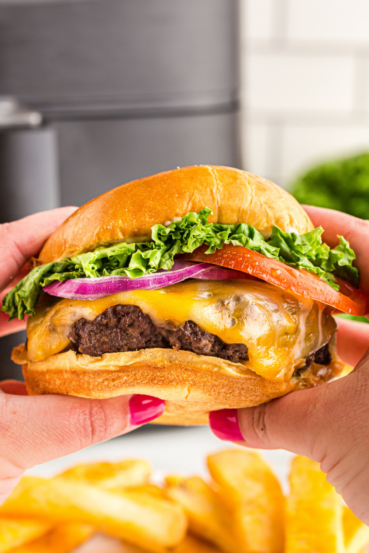 Classic McDonald’s-style cheeseburger with melted cheese, soft bun, and crispy smash burger patty stacked on a plate.