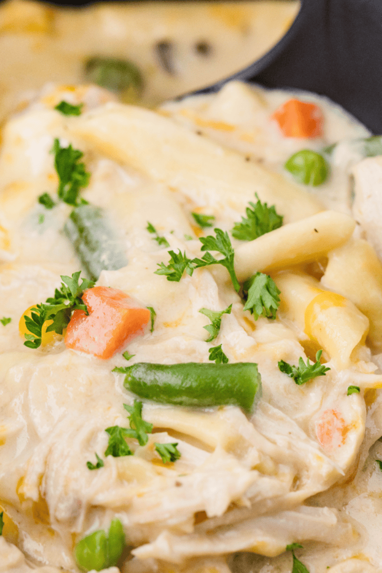 Slow cooker chicken pot pie pasta with creamy sauce and mixed vegetables ready to serve.