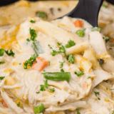 Creamy Crock Pot Chicken Pot Pie Pasta served in a bowl with chicken, peas, carrots, and pasta.