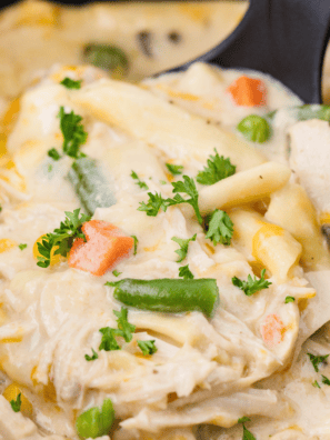 Creamy Crock Pot Chicken Pot Pie Pasta served in a bowl with chicken, peas, carrots, and pasta.
