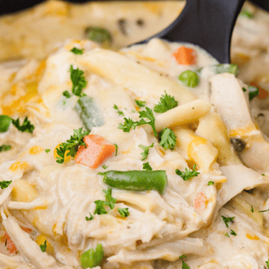 Creamy Crock Pot Chicken Pot Pie Pasta served in a bowl with chicken, peas, carrots, and pasta.
