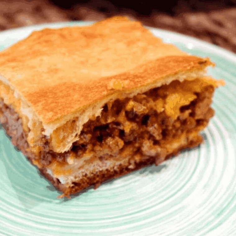 Skillet of Sloppy Joe mix with ground beef simmering in a thick, rich tomato-based sauce.
