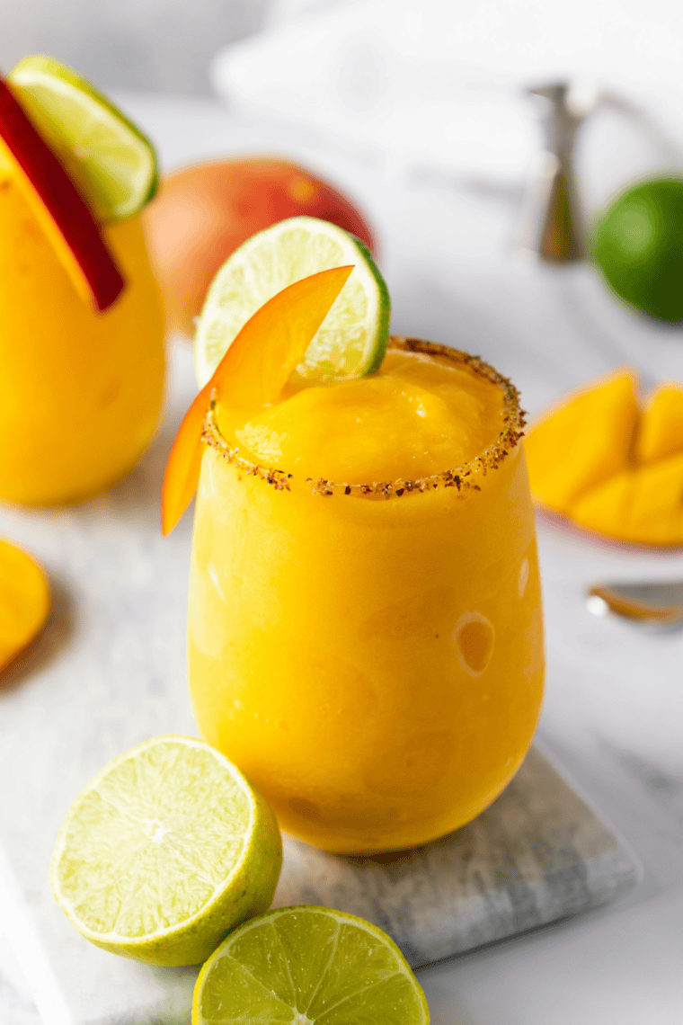 mango margarita slushy drink with crushed ice and mango slices