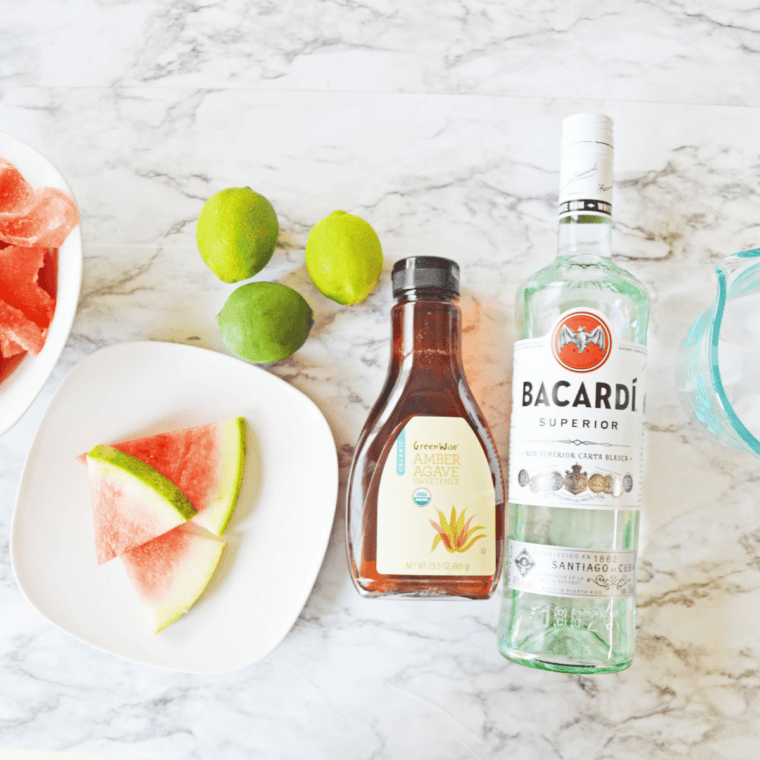 
Ingredients for Ninja Slushi Watermelon Daiquiri arranged on a kitchen counter, including fresh watermelon juice, white rum, fresh lime juice, and granulated sugar.