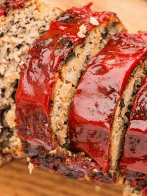One pound meatloaf sliced on a cutting board showing a juicy, tender interior with a rich glaze on top.