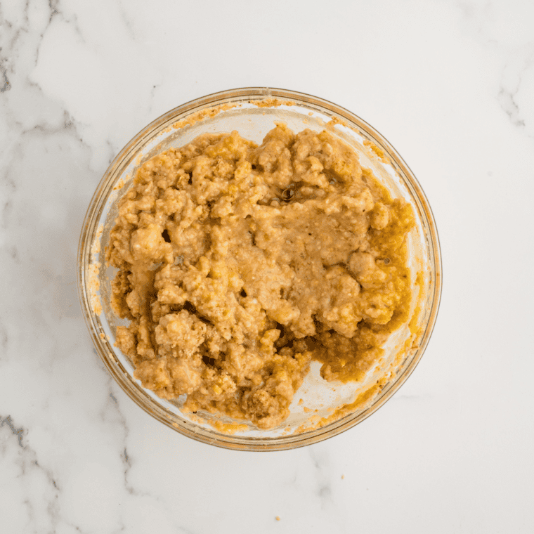 Make the Panade
Plain breadcrumbs soaking in whole milk in a glass mixing bowl, forming a thick paste for the meatloaf panade.