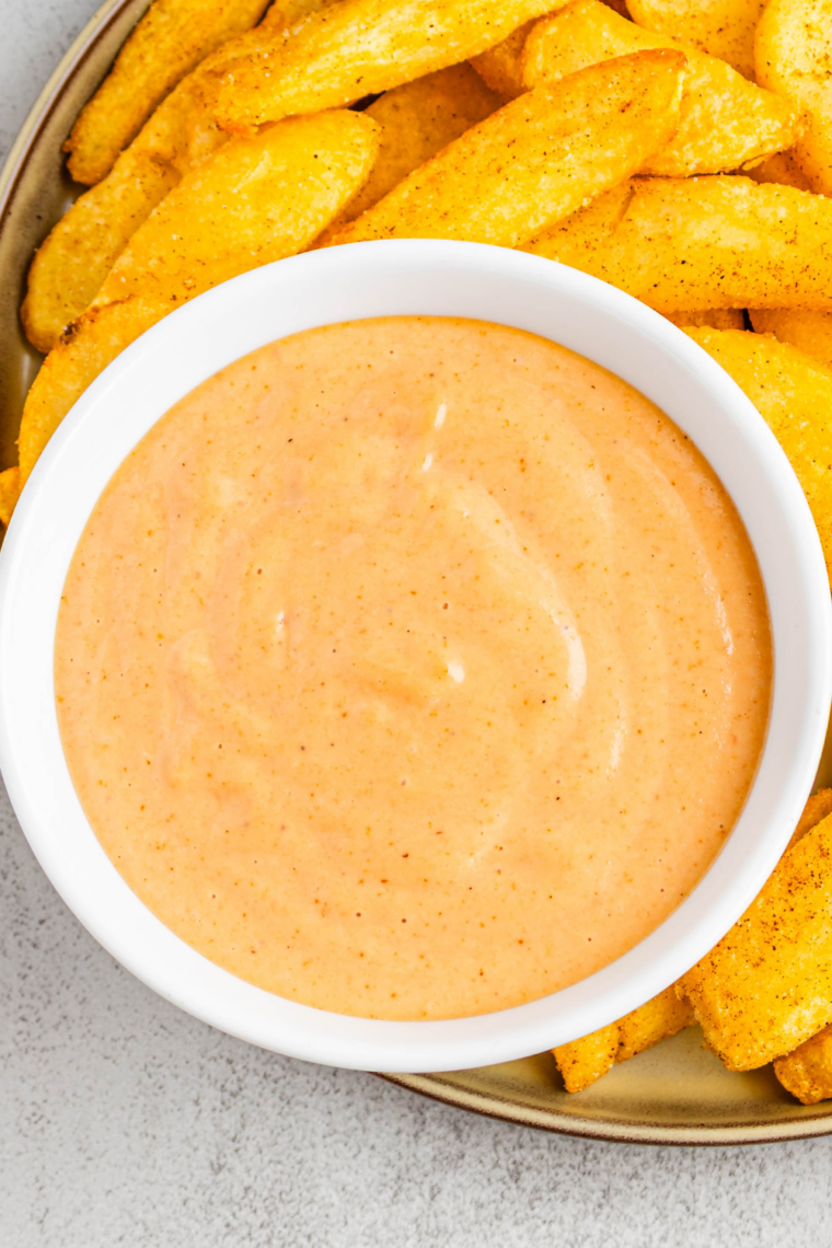 Bowl of creamy Popeyes signature sauce served as a dipping sauce for chicken tenders and fries