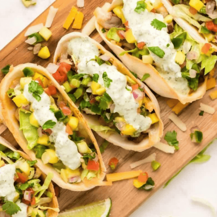 Creamy spicy crema sauce drizzled over tacos with a smooth orange-pink color and fresh garnish.