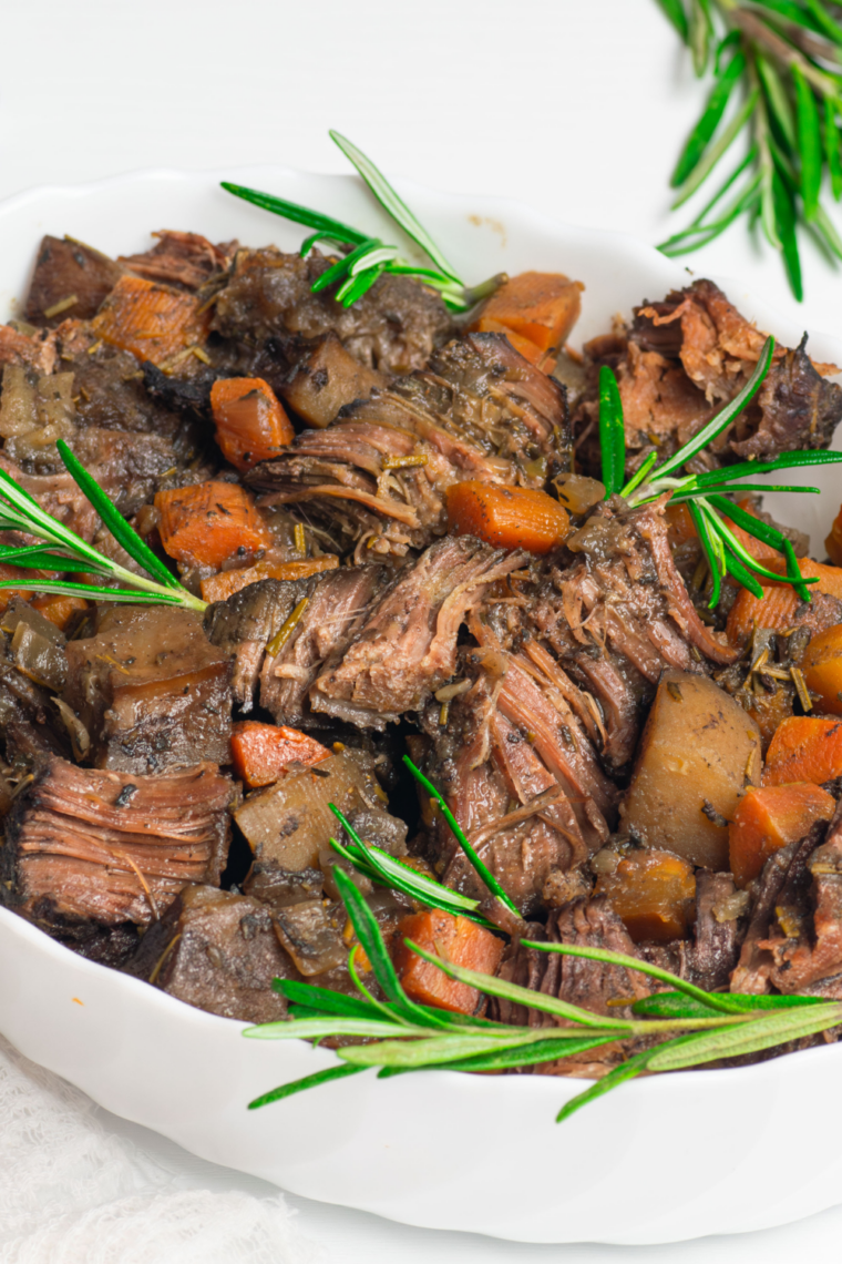 DIY pot roast seasoning mix made with dried herbs, garlic powder, and spices in a glass jar.