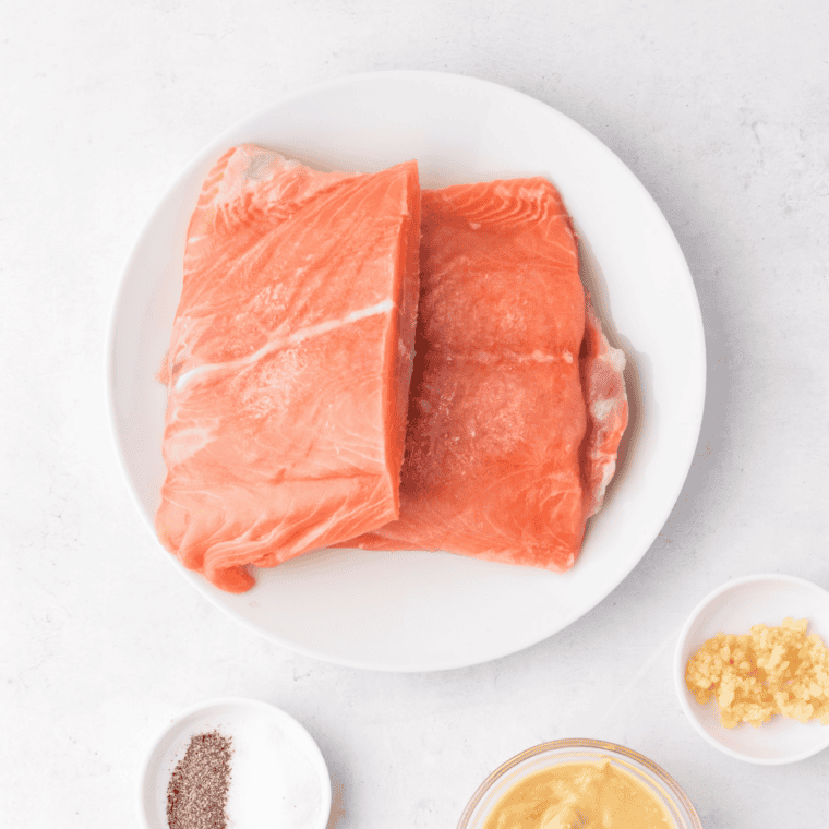 Ingredients for air fryer Jack Daniel's glazed salmon laid out, including salmon fillets, brown sugar, pineapple juice, soy sauce, and Jack Daniel's whiskey
