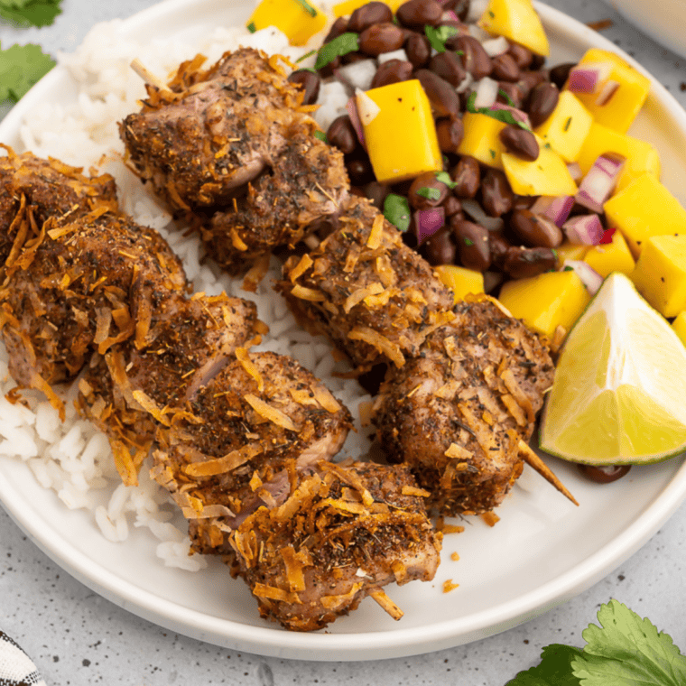 Air fryer jerk pork skewers with black bean mango salsa on a serving platter