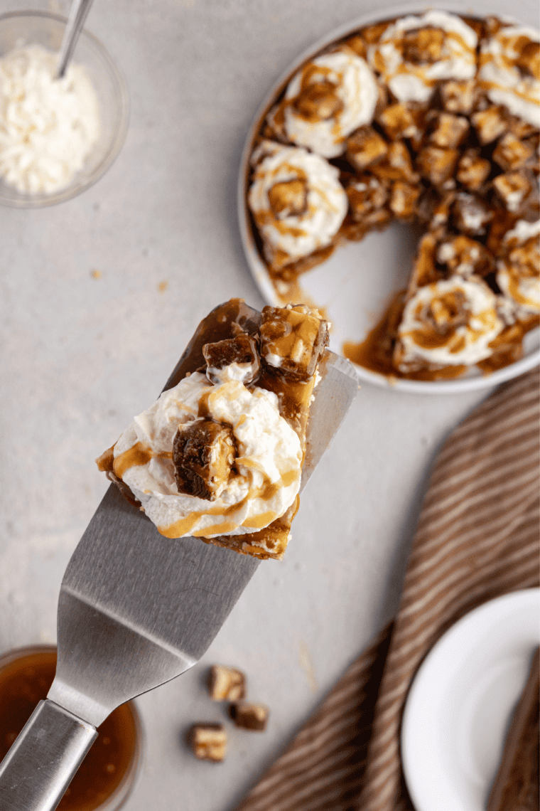 Creamy air fryer Snickers cheesecake with a slice cut, showing chopped Snickers inside the filling