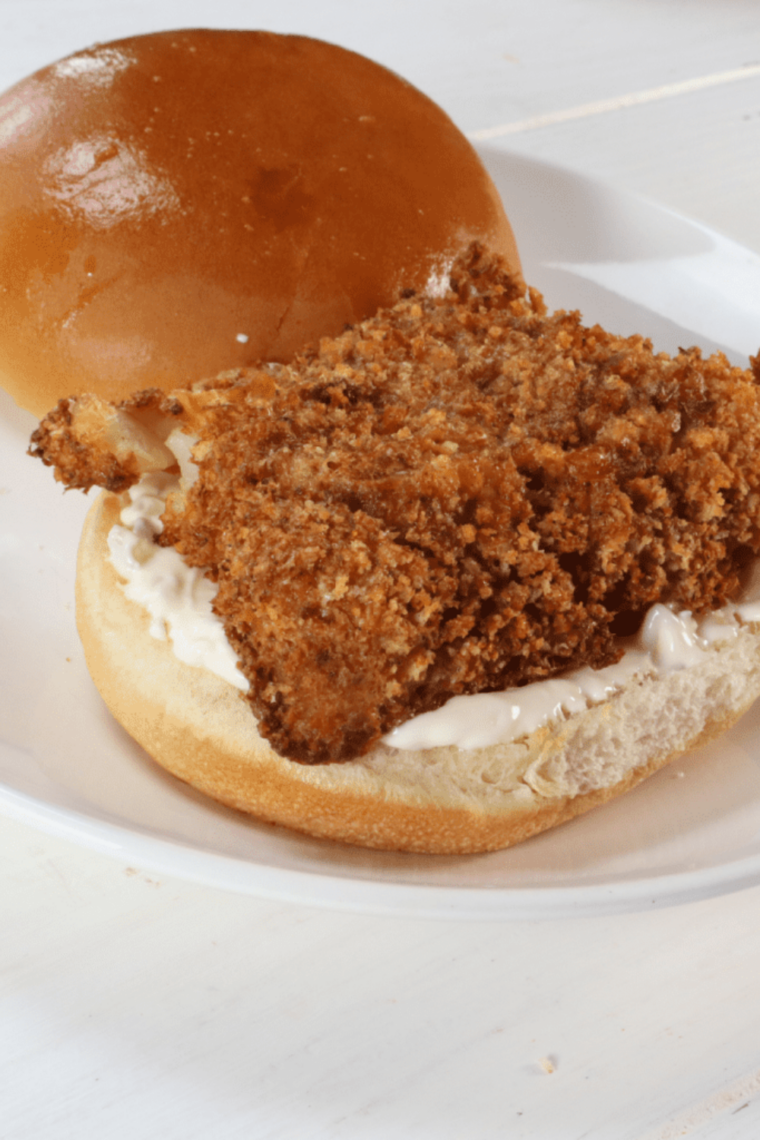 Homemade copycat Burger King fish sandwich cut in half showing the crispy panko pollock fillet inside