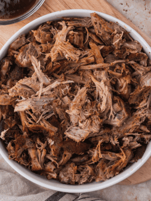 Shredded smoked pulled pork in a white bowl seasoned with copycat Jack Daniel's pork rub