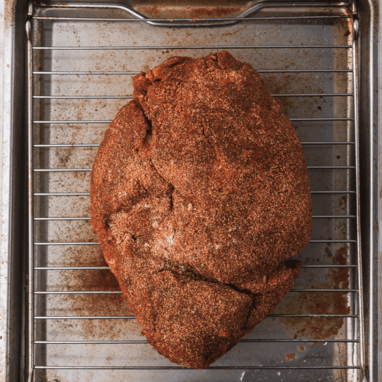 Dry rub being massaged into pork before refrigerating and grilling