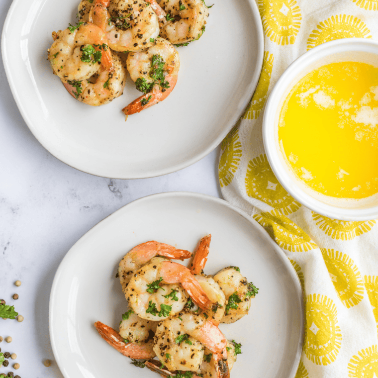Copycat McCormick lemon pepper seasoning on sautéed shrimp in a skillet with lemon wedges